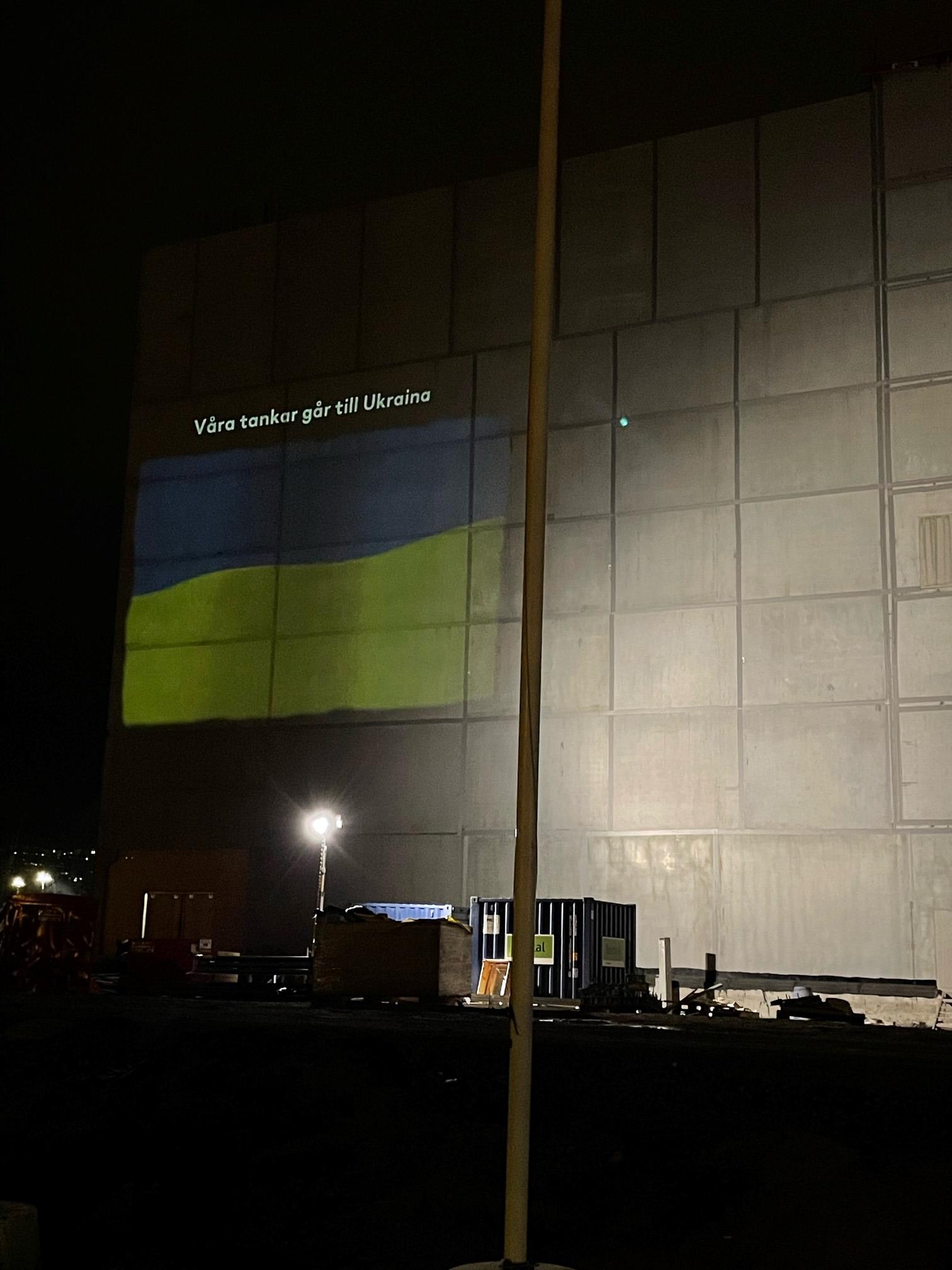 Belysning av vägg på parkeringshus Övertaget med Ukrainas flagga samt texten "Våra tankar går till Ukraina"