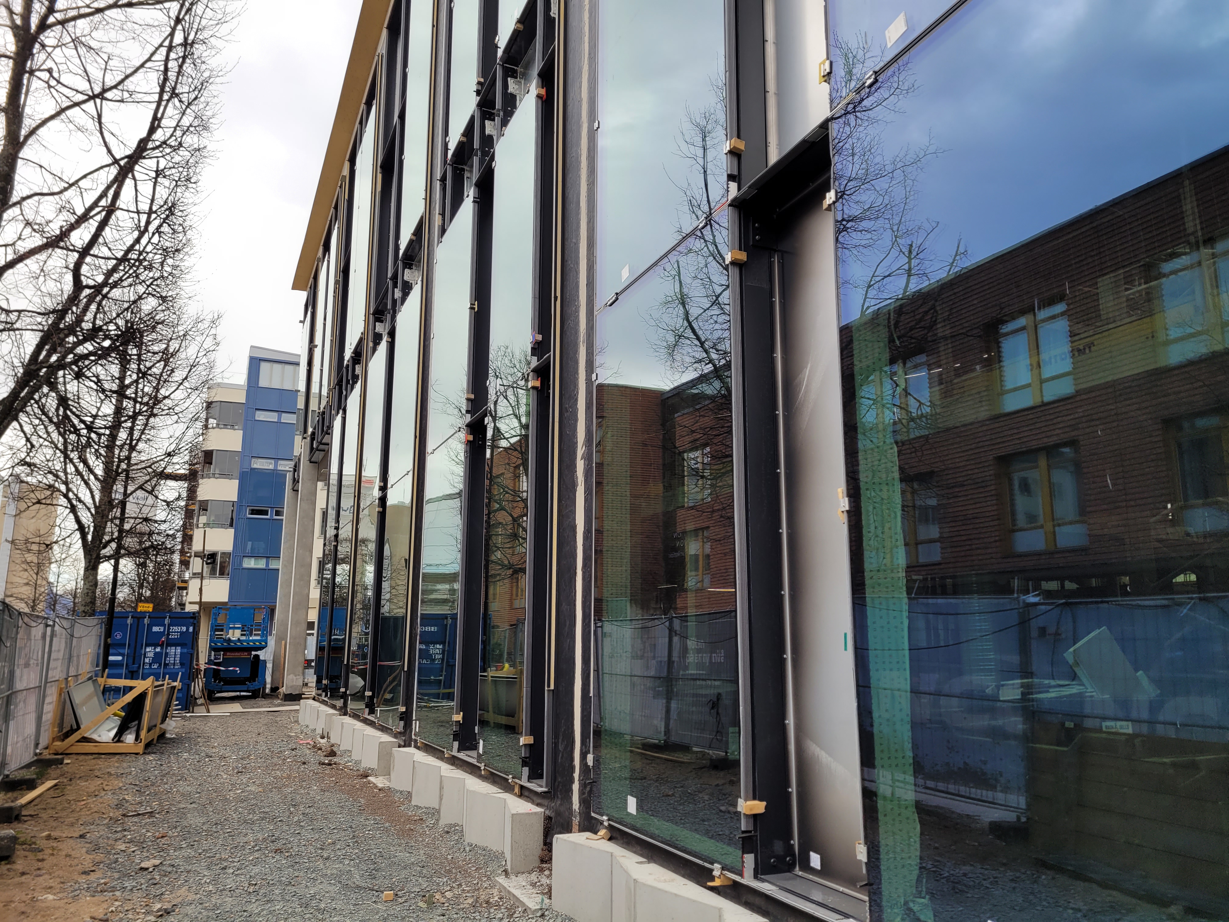 Detaljbild på fasaden mot Barnarpsgatan med de färdigmonterade glaspartierna.